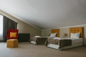 Room with two beds and an armchair